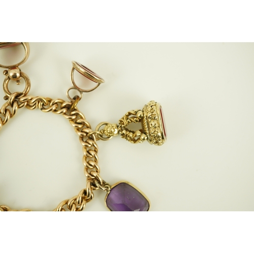 165 - An Edwardian 15ct gold curb link charm bracelet with heart shaped padlock clasp, hung with six assor... 