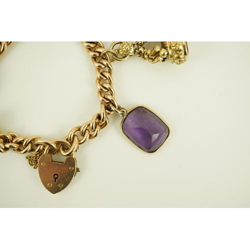 165 - An Edwardian 15ct gold curb link charm bracelet with heart shaped padlock clasp, hung with six assor... 