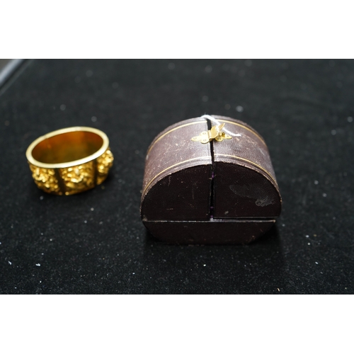 173 - An early 20th century Indian gold hinged panelled cuff bracelet, embossed with deities amongst scrol... 