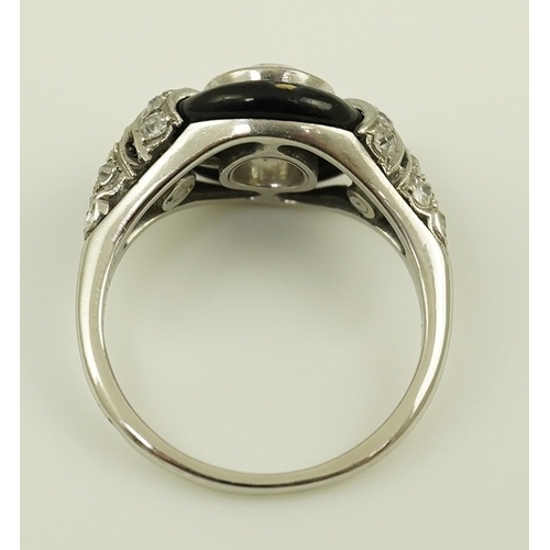 185 - An Art Deco platinum black enamel and diamond set ring, with diamond set shoulders, the central ston... 