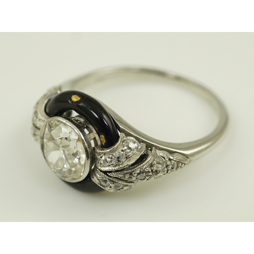 185 - An Art Deco platinum black enamel and diamond set ring, with diamond set shoulders, the central ston... 