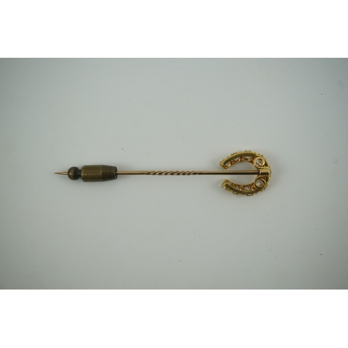 186 - An early 20th century gold and nine stone graduated old cut diamond set horseshoe stick pin, 68mm, g... 