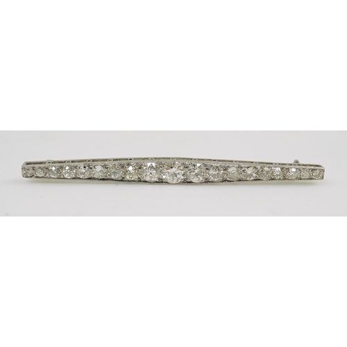 187 - A 1920's platinum? and nineteen millegrain set graduated diamond bar brooch, 59mm, gross weight 4.6 ... 