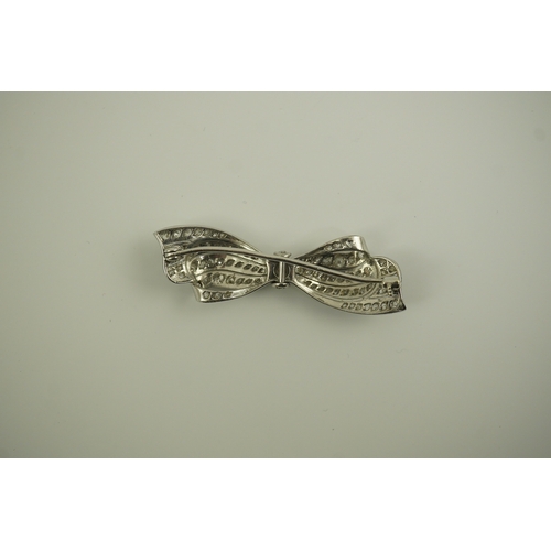 195 - A 1940's platinum? and diamond cluster set ribbon bow brooch, with central old mine cut stone, 49mm,... 