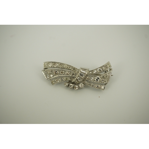 196 - A mid 20th century platinum? and diamond cluster scroll brooch, set with baguette and round cut diam... 