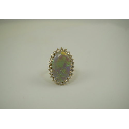 225 - An 18ct  gold, white opal and diamond set oval cluster dress ring, the cabochon opal measuring appro... 