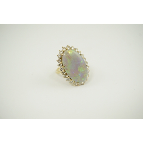 225 - An 18ct  gold, white opal and diamond set oval cluster dress ring, the cabochon opal measuring appro... 