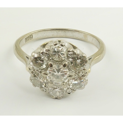 228 - An 18ct white gold, and seven stone diamond set flower head cluster ring, size N, gross weight 4.2 g... 