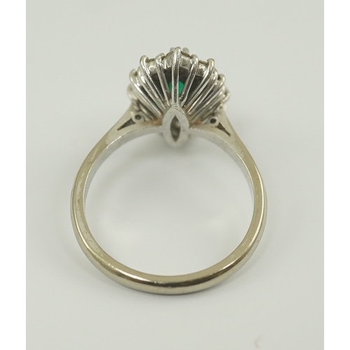 231 - A modern 18ct white gold and single stone marquise cut emerald set ring, bordered with round brillia... 