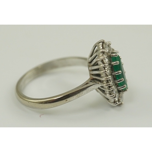 231 - A modern 18ct white gold and single stone marquise cut emerald set ring, bordered with round brillia... 