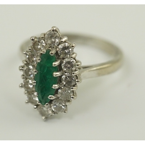 231 - A modern 18ct white gold and single stone marquise cut emerald set ring, bordered with round brillia... 