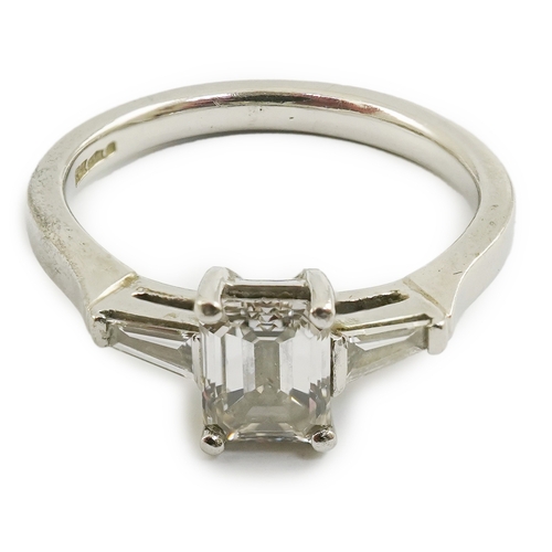 235 - A modern platinum and single stone emerald cut diamond set ring, with two stone tapered baguette cut... 