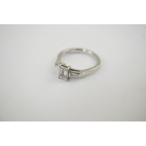 235 - A modern platinum and single stone emerald cut diamond set ring, with two stone tapered baguette cut... 