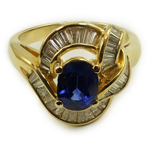 236 - A modern 18k gold, sapphire and diamond cluster set dress ring, with oval cut sapphire and tapered b... 