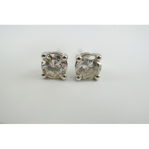 237 - A modern pair of 18k white gold and solitaire diamond set ear studs, the stone diameters approximate... 