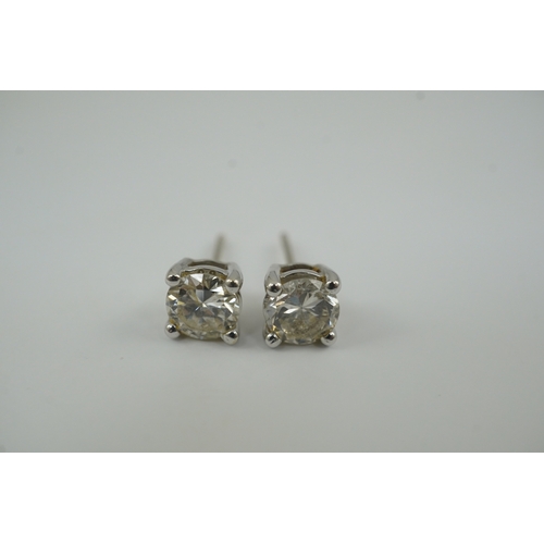 237 - A modern pair of 18k white gold and solitaire diamond set ear studs, the stone diameters approximate... 