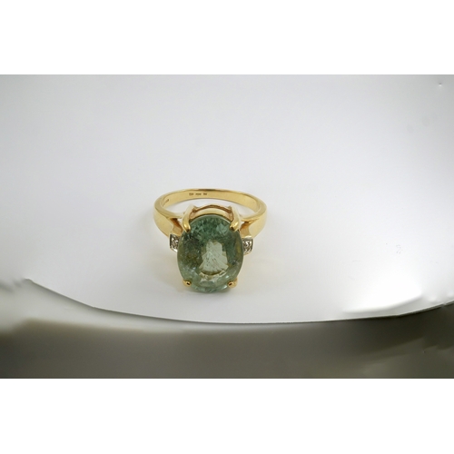 246 - A modern 18ct gold and oval cut pale green tourmaline set dress ring, with two stone diamond chip se... 