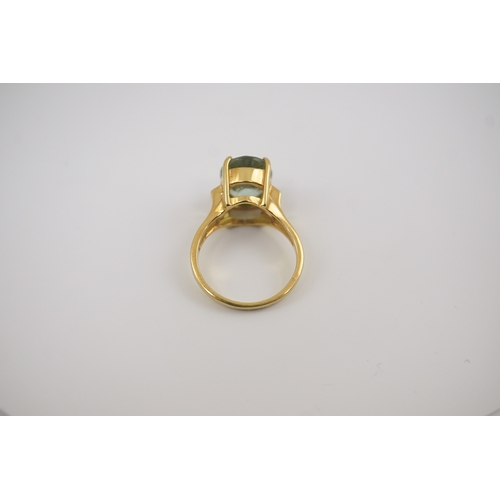 246 - A modern 18ct gold and oval cut pale green tourmaline set dress ring, with two stone diamond chip se... 