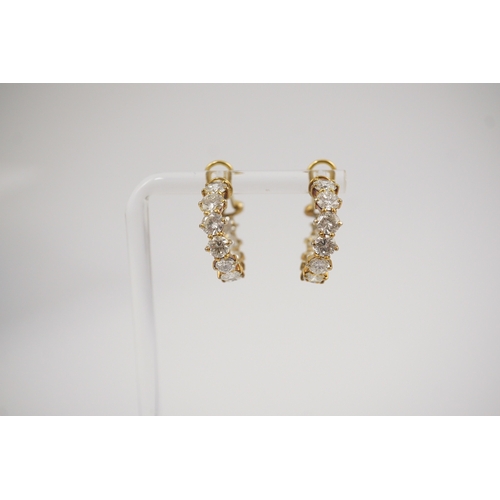 247 - A modern pair of 18ct gold and graduated eleven stone round brilliant cut diamond set hoop earrings,... 