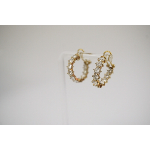 247 - A modern pair of 18ct gold and graduated eleven stone round brilliant cut diamond set hoop earrings,... 