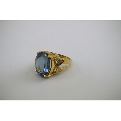 248 - A modern 18ct gold and single stone oval cut tanzanite set dress ring, with eight stone diamond chip... 