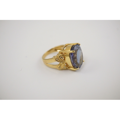 248 - A modern 18ct gold and single stone oval cut tanzanite set dress ring, with eight stone diamond chip... 