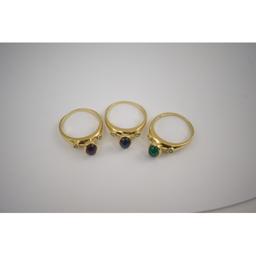 252 - A suite of three modern 18k gold and gem set rings, each set with a cabochon emerald, sapphire or ru... 