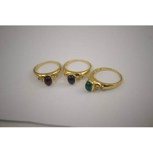 252 - A suite of three modern 18k gold and gem set rings, each set with a cabochon emerald, sapphire or ru... 