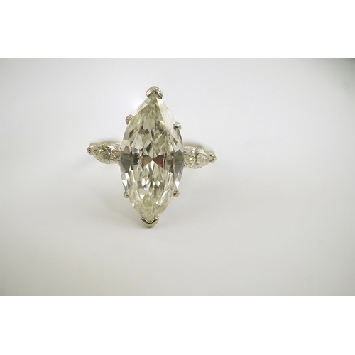 254 - A modern 18ct white gold and single stone marquise cut diamond set ring, with two stone marquise cut... 