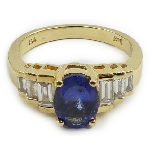 255 - A modern 14k gold and single stone oval cut tanzanite set dress ring, with six stone graduated bague... 