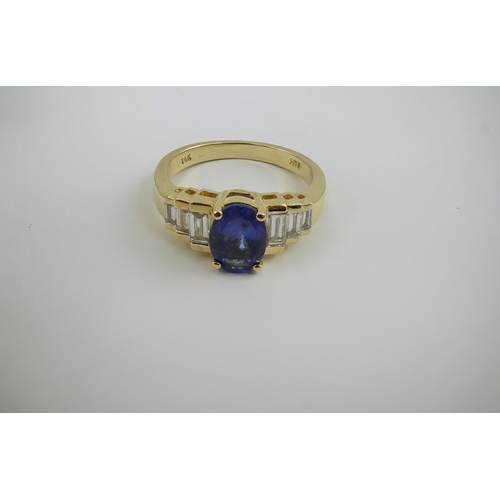 255 - A modern 14k gold and single stone oval cut tanzanite set dress ring, with six stone graduated bague... 