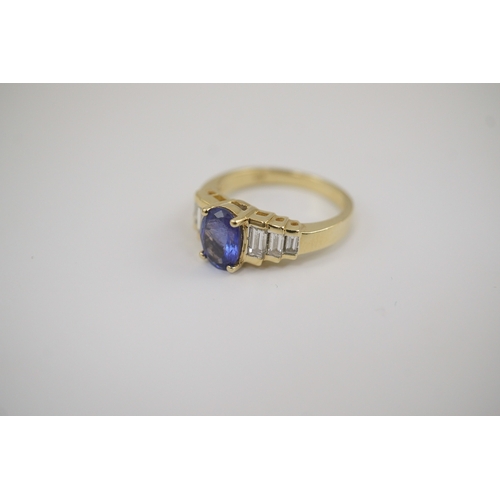 255 - A modern 14k gold and single stone oval cut tanzanite set dress ring, with six stone graduated bague... 