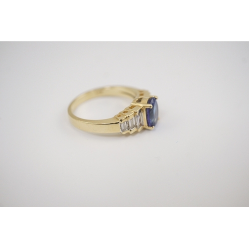 255 - A modern 14k gold and single stone oval cut tanzanite set dress ring, with six stone graduated bague... 