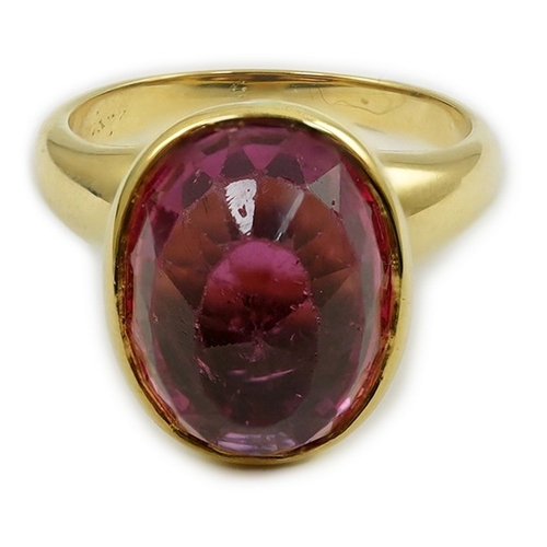 257 - A modern 18k gold and single stone fancy oval cut deep pink tourmaline set dress ring, signed Asprey... 