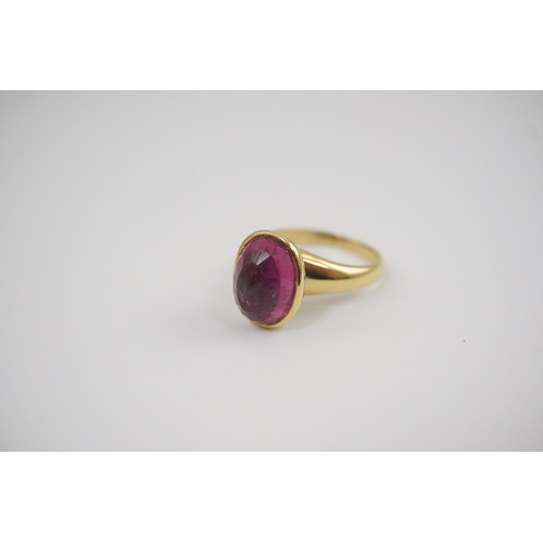 257 - A modern 18k gold and single stone fancy oval cut deep pink tourmaline set dress ring, signed Asprey... 