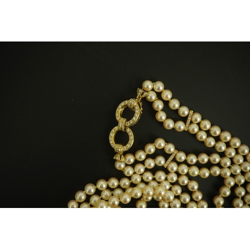 267 - A modern double strand cultured pearl necklace, with 18k gold and diamond set twin ring clasp, and t... 