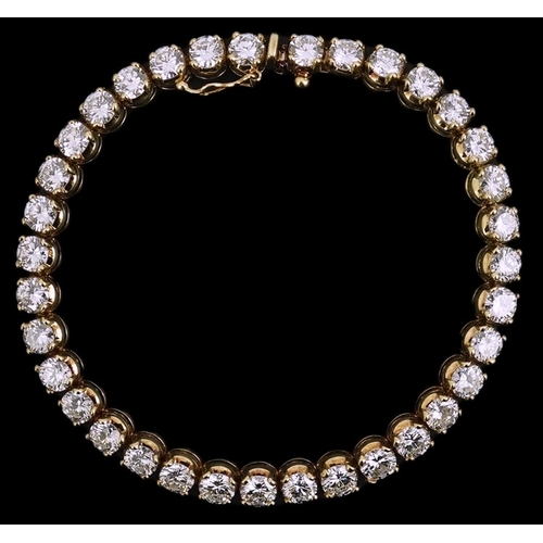 268 - A modern 14k gold and thirty five stone round brilliant cut diamond set tennis bracelet, each stone ... 