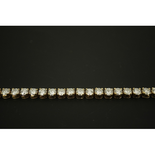 268 - A modern 14k gold and thirty five stone round brilliant cut diamond set tennis bracelet, each stone ... 