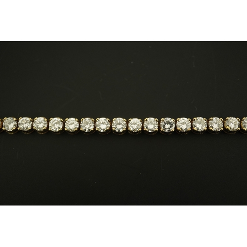 268 - A modern 14k gold and thirty five stone round brilliant cut diamond set tennis bracelet, each stone ... 