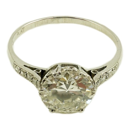 284 - A platinum and single stone diamond set ring, with graduated eight stone diamond chip set shoulders,... 