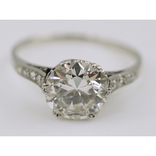 284 - A platinum and single stone diamond set ring, with graduated eight stone diamond chip set shoulders,... 