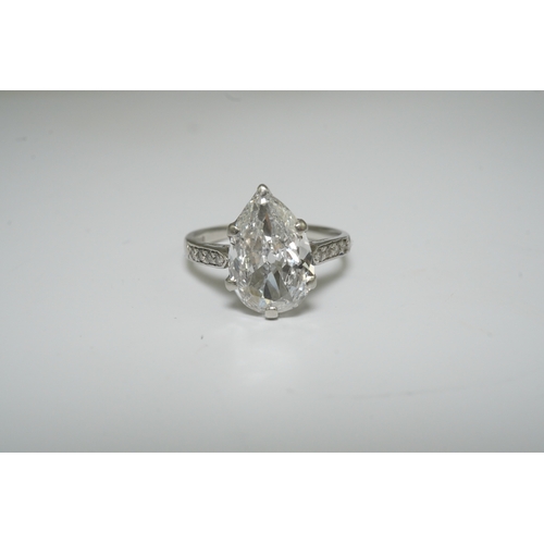 285 - A platinum and pear cut single stone diamond set ring, with diamond set shoulders, the stone weighin... 