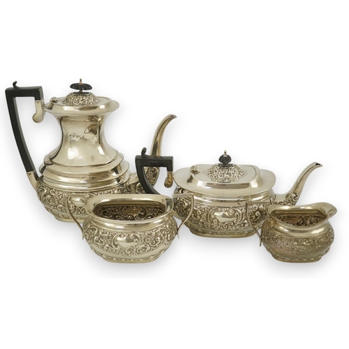 38 - An Edwardian embossed silver four piece tea and coffee set, by S. Glass, decorated with foliate scro... 