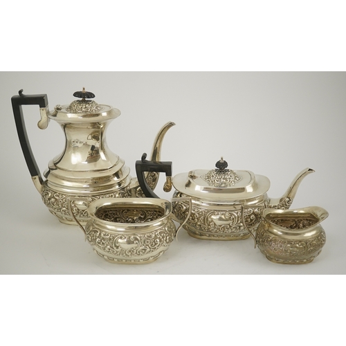 38 - An Edwardian embossed silver four piece tea and coffee set, by S. Glass, decorated with foliate scro... 