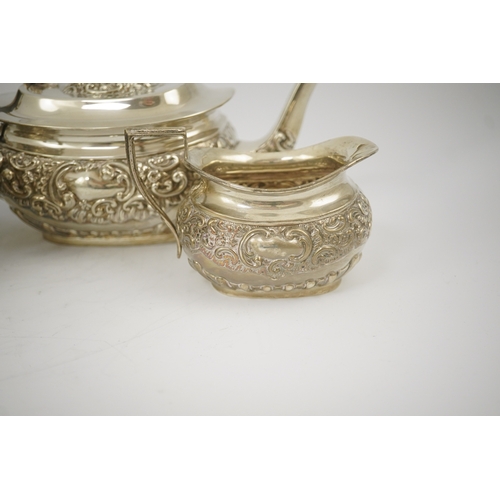 38 - An Edwardian embossed silver four piece tea and coffee set, by S. Glass, decorated with foliate scro... 