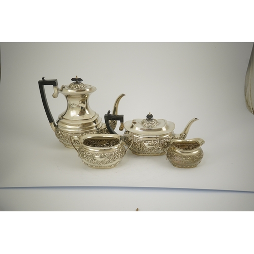 38 - An Edwardian embossed silver four piece tea and coffee set, by S. Glass, decorated with foliate scro... 