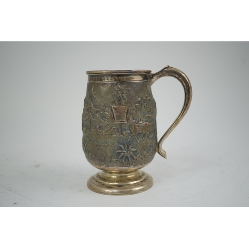 39 - A 20th century Indian silver baluster mug, embossed with continuous village scene with figures and a... 