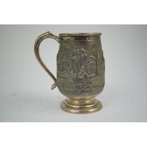 39 - A 20th century Indian silver baluster mug, embossed with continuous village scene with figures and a... 