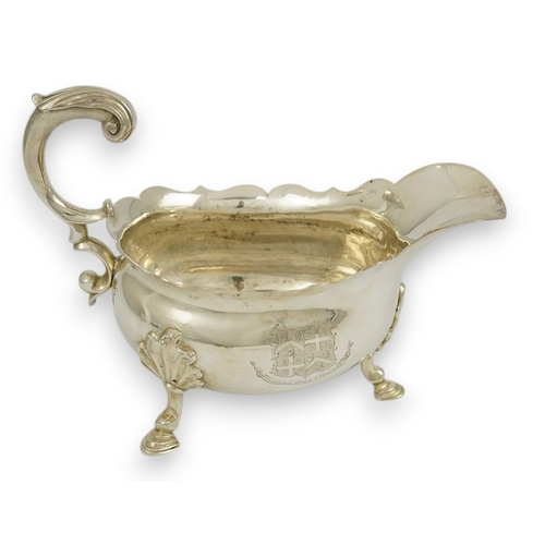 5 - A George II silver sauceboat, by William Shaw II & William Priest, with engraved armorials cut borde... 