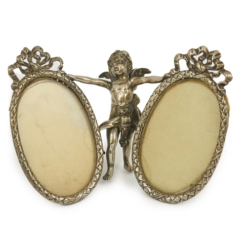 50 - A late 19th century Hanau silver double oval photograph frame, supported by central figure of Cupid,... 